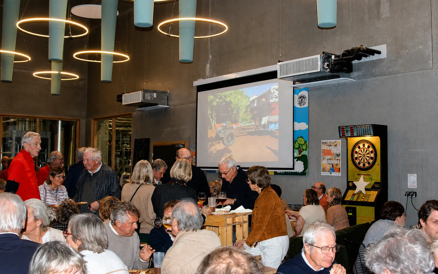 Soirée solidaire à la brasserie Moulins d'Ascq : les convives attablés devant la projection des images du village